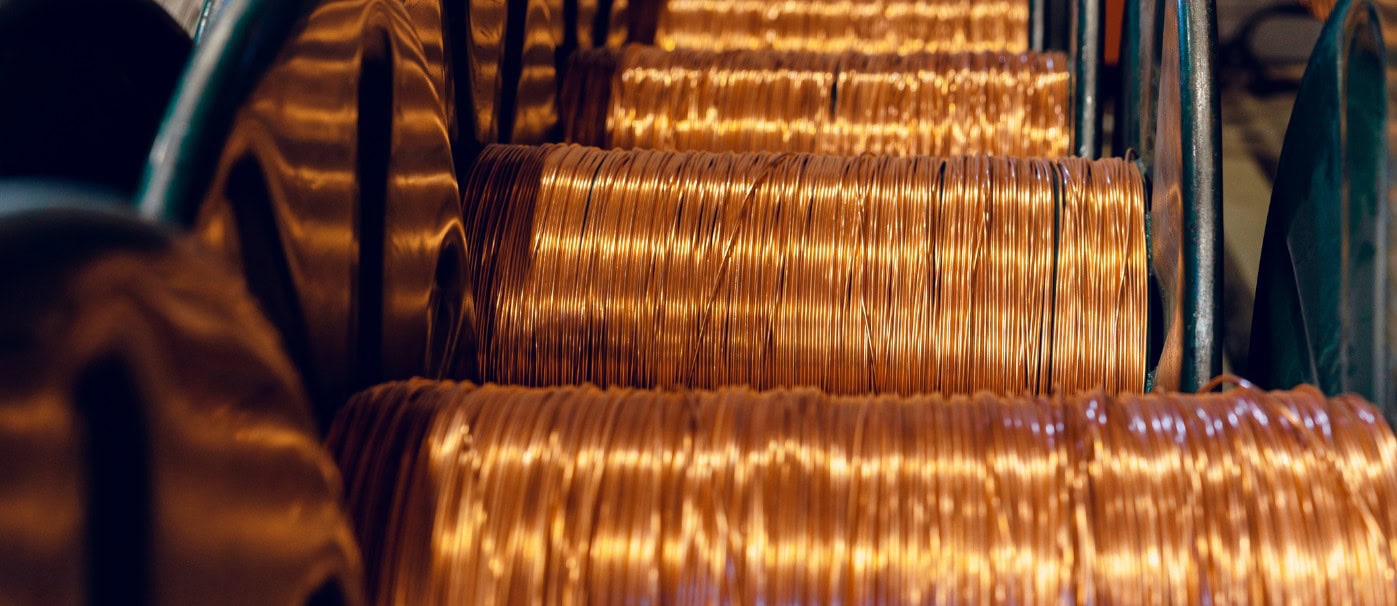 Copper wire spools in a manufacturing facility, showcasing industrial wiring and electrical componen.