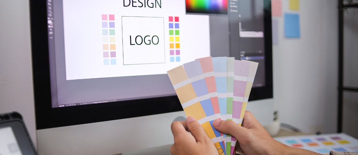 A person selecting colour swatches for graphic design on a computer screen.