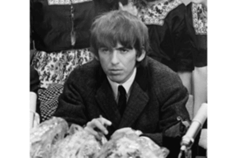 A young boy with a serious expression sitting at a table in a black and white photo.