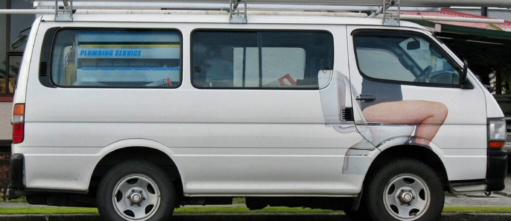 A van with a plumbing service advertisement on the side.