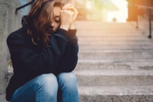 young girl appearing sad sitting on steps