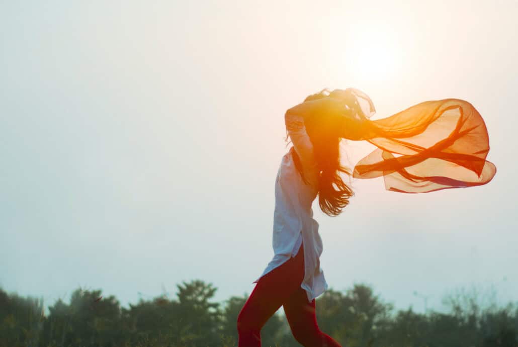 woman waving in breeze with sunlight