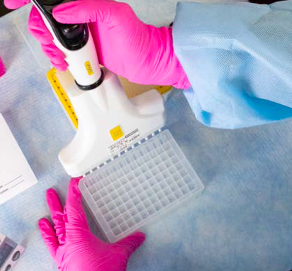 Genomind lab sample array aerial shot with lab technician with pink gloves holding device