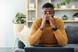 man thinking with hands in between his eyes