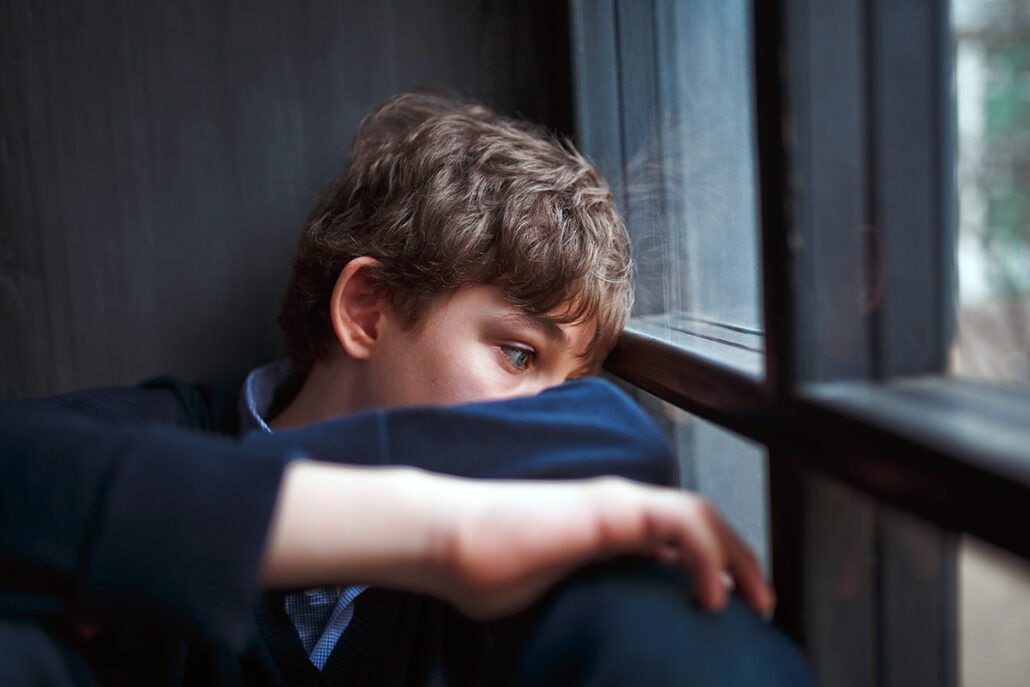 little boy leaning against window