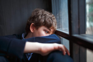 little boy leaning against window