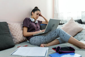 girl sitting in bed on computer