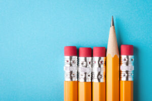 five pencils lined up with four facing downward and one facing upward