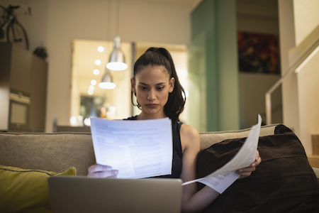 woman sitting on couch reviewing papers