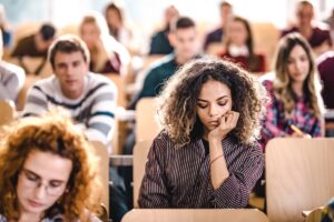 girl sitting in class looking down at notes