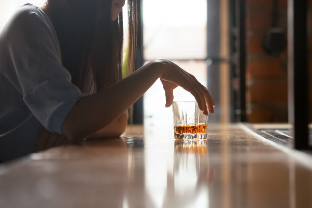 person holding glass at bar