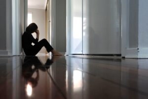 woman sitting on floor with head down