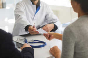 doctor handing patient piece of paper