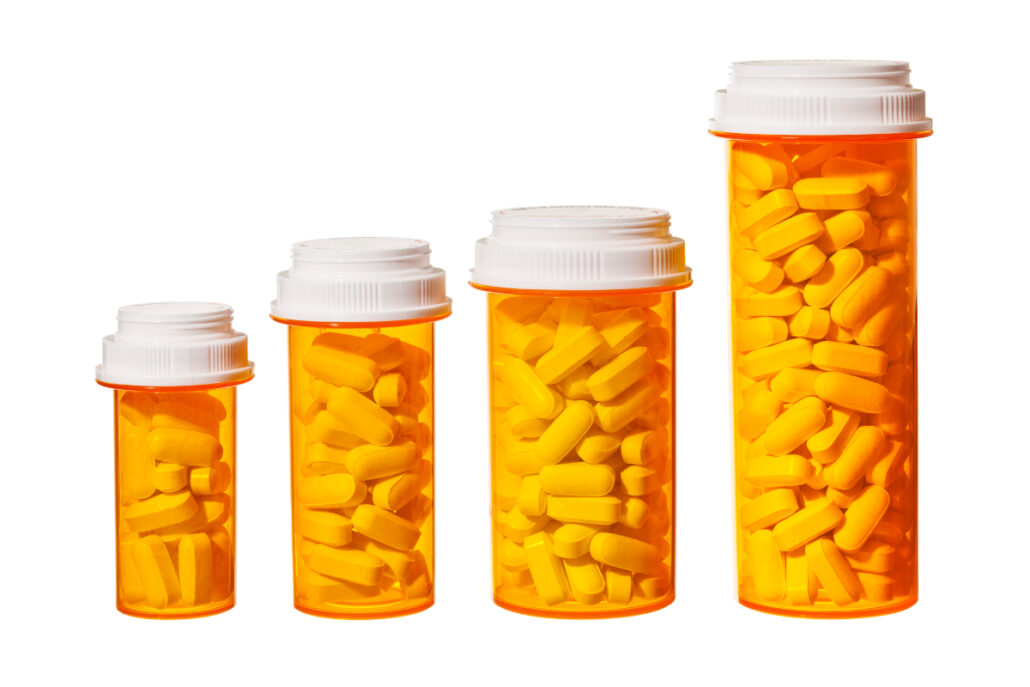 four pill bottles varying in size smallest to largest