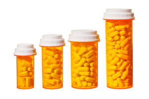 four pill bottles varying in size smallest to largest