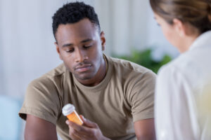 man examining pill bottle