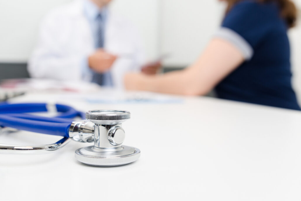 stethoscope with patient and doctor in background