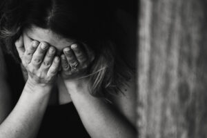 woman covering eyes and leaning over