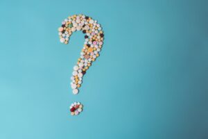 assorted pills forming question mark