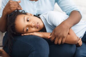 girl lying in mother's lap