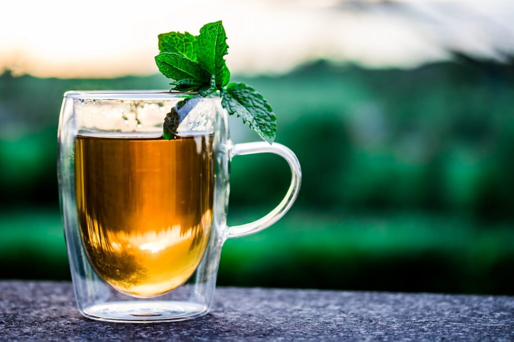 kombucha in clear mug with basil leaf