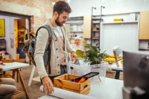 young man packing up desk at work