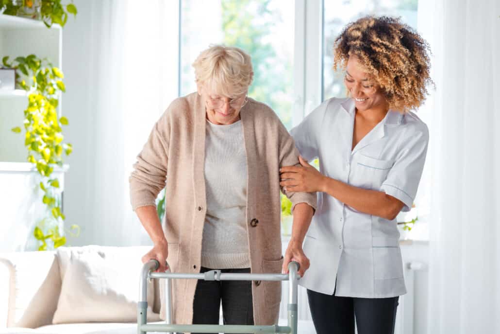 senior woman and caregiver holding on walker