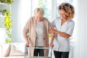 senior woman and caregiver holding on walker