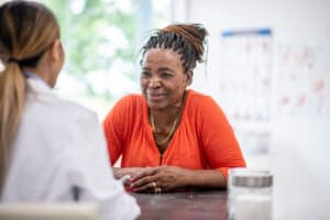 older African-American woman consulting clinician about how to avoid medication errors