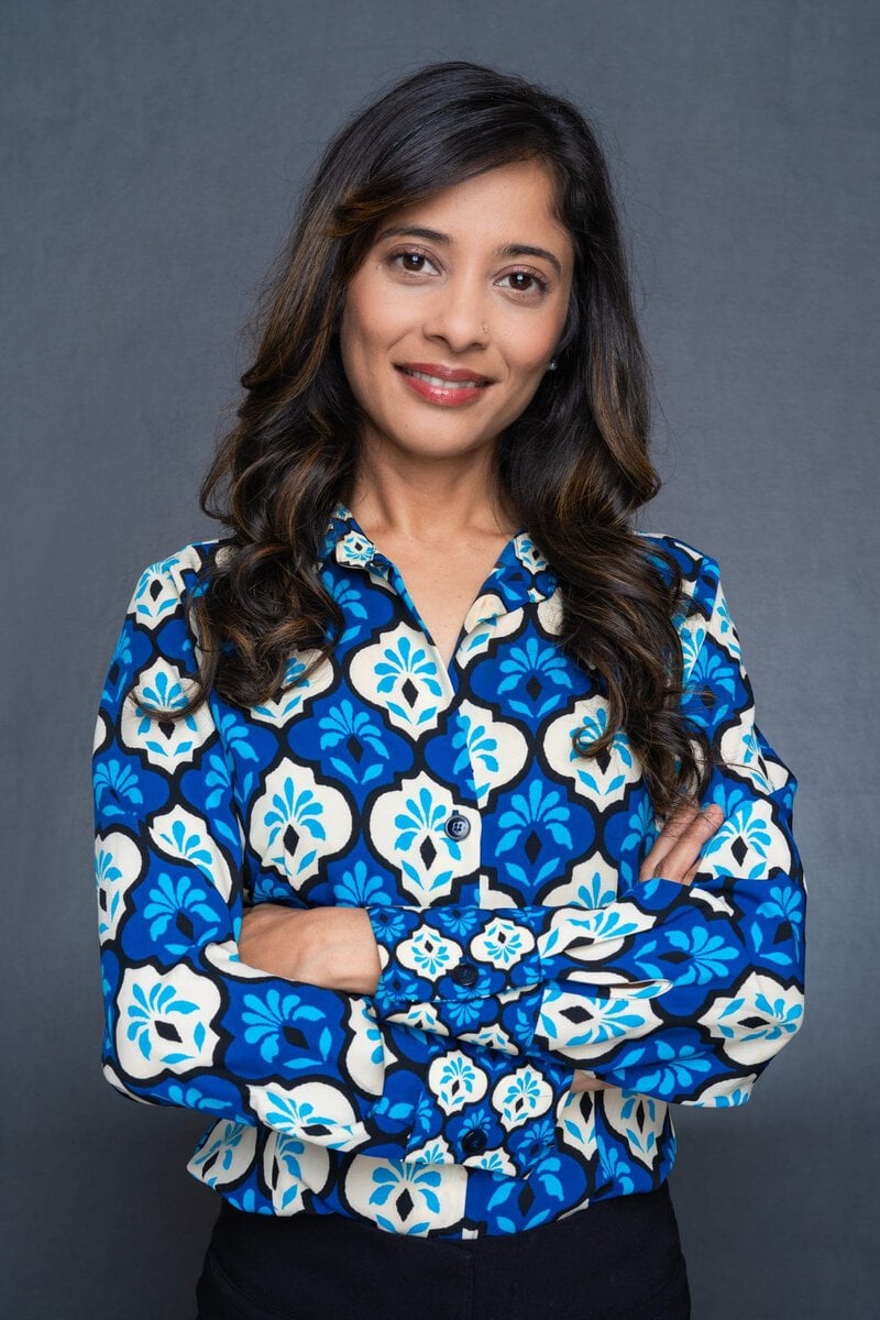 Int: Young Indian woman wearing a blue skirt having LinkedIn headshot taken by Professional Photographer Georgie Greene in Sydney NSW