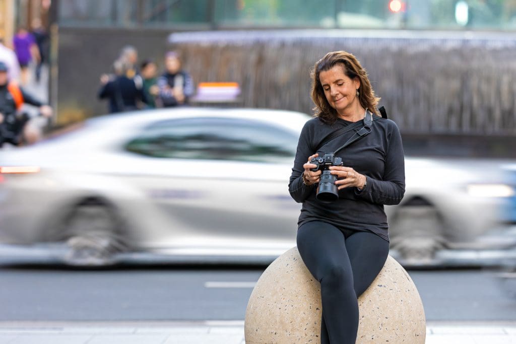 Georgie Greene Headshots and Personal Branding photographer looking at her camera in a Sydney Street
