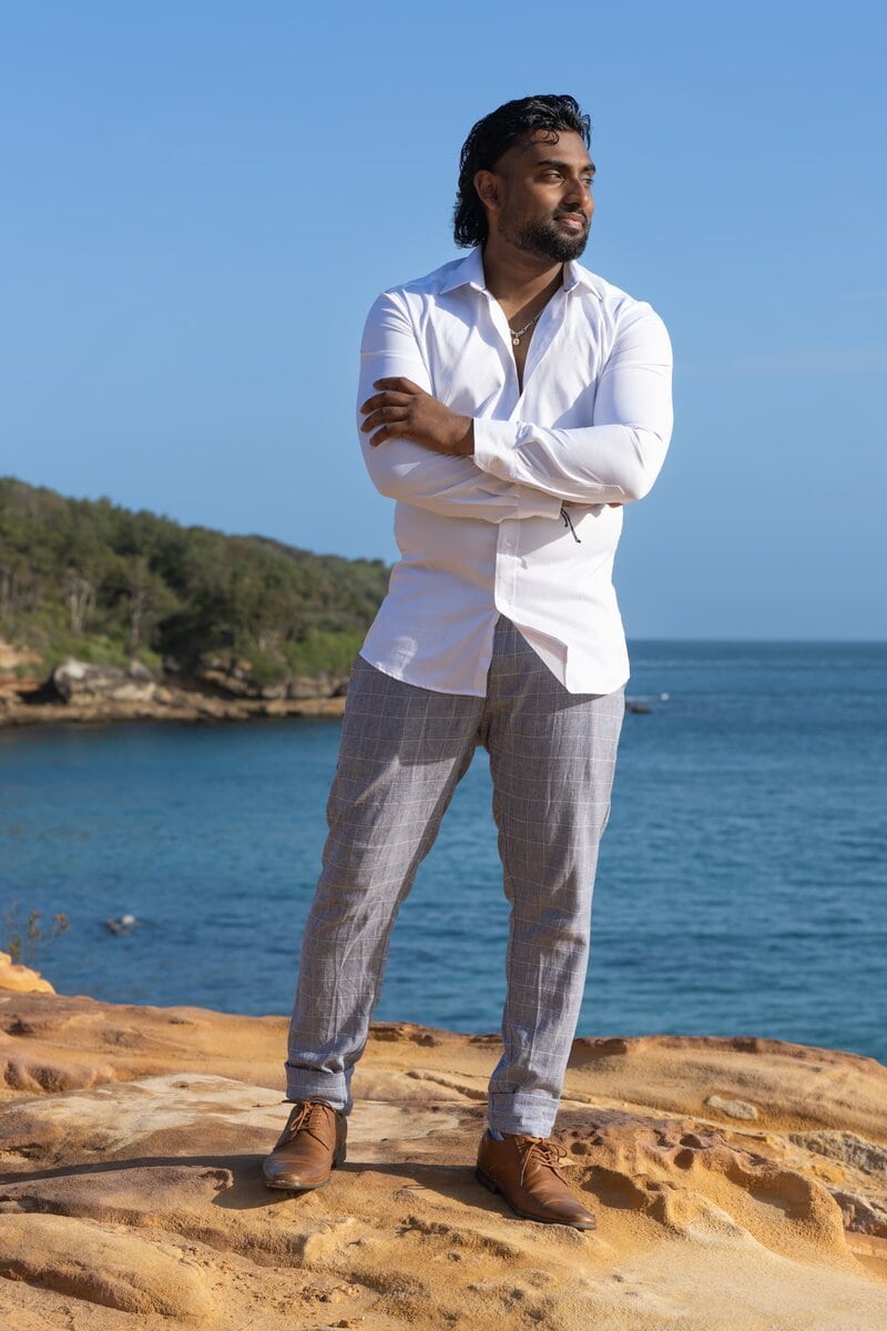 Ext: Young Indian man in white having an ocean location dating photoshoot with dating photographer Georgie Greene in Sydney NSW