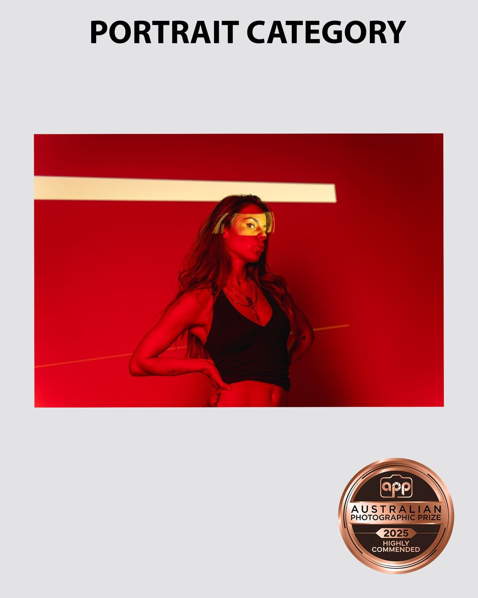 Portrait of a model bathed in red light as she blows a kiss taken by Sydney professional photographer Georgie Greene