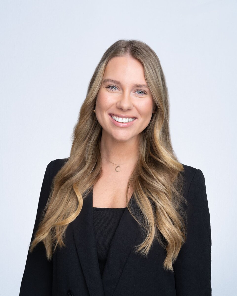 Young blonde woman wearing a black jacket having her company headshot taken by Sydney professional photographer Georgie Greene