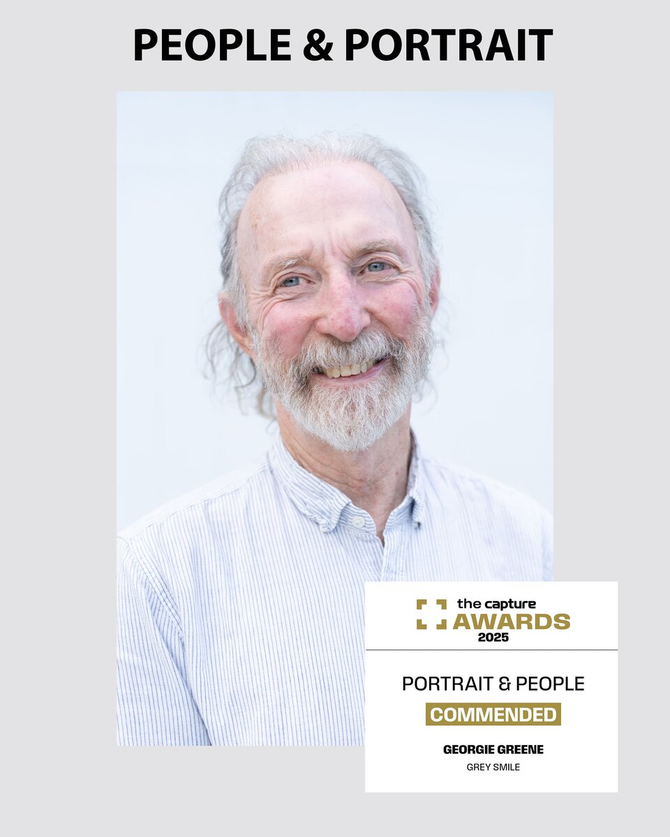 Portrait of a grey haired man with a grey beard smiling