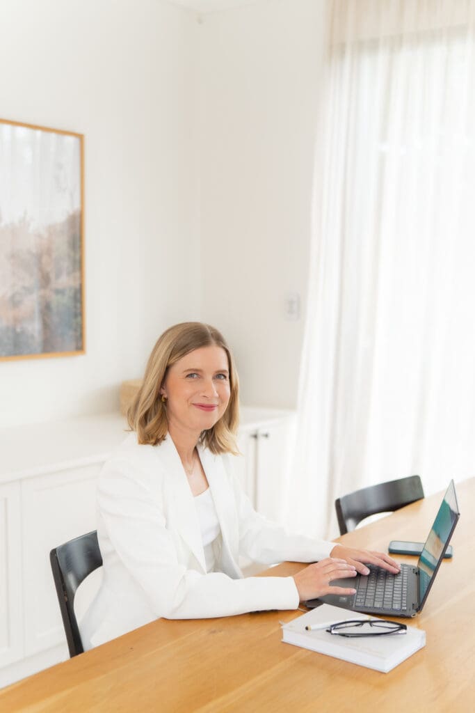 Sydney-Branding-Photography-Of-A-Leadership-Coach – Professional Photographer Sydney Woman in a white jacket at her laptop and having her personal branding taken by Sydney personal branding photographer Georgie Greene