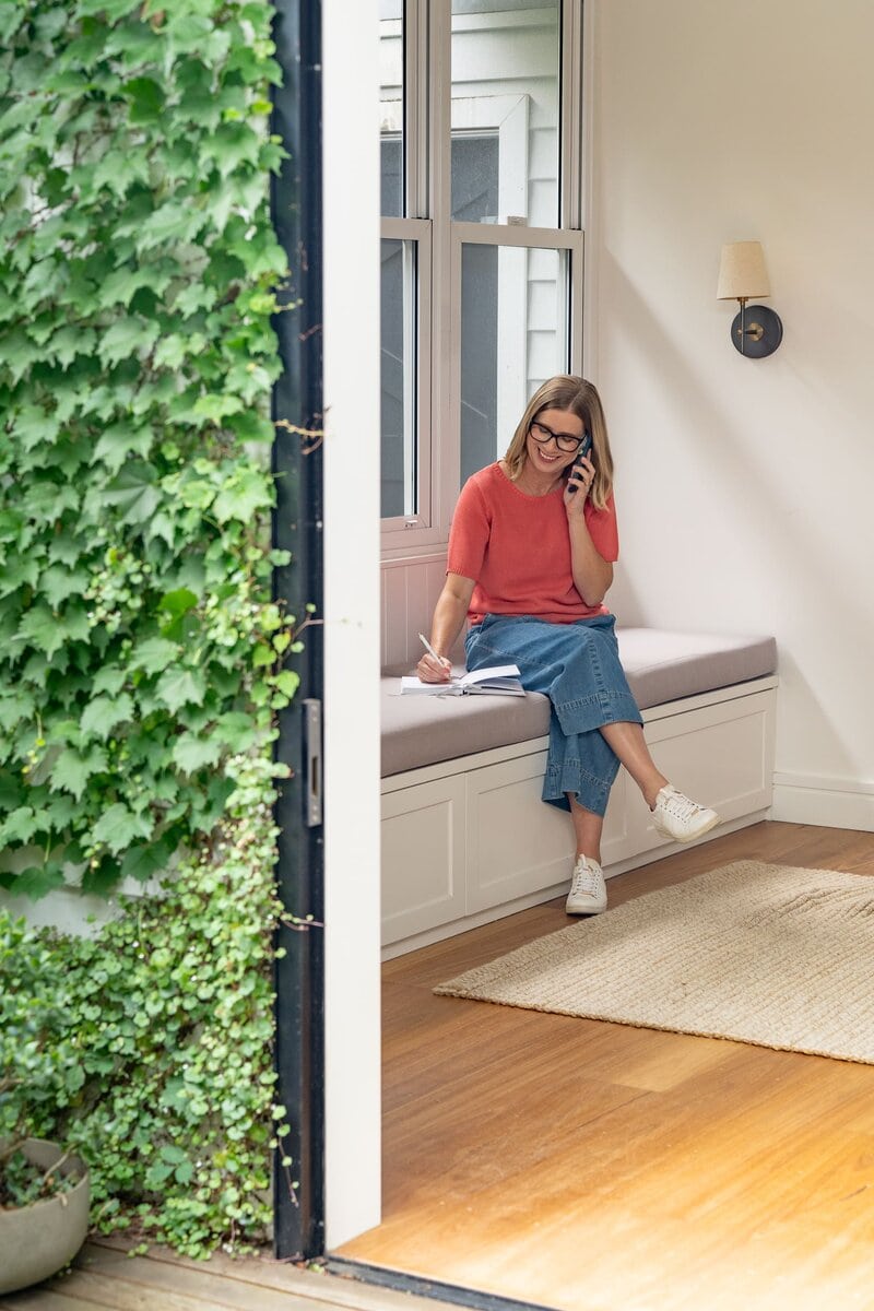 Woman in a coral top on the phone and having her personal branding taken by Sydney personal branding photographer Georgie Greene
