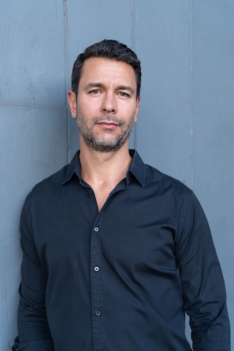 Headshot of a dark hair man with beard wearing a black shirt having his dating photo taken by top Sydney dating photographer Georgie