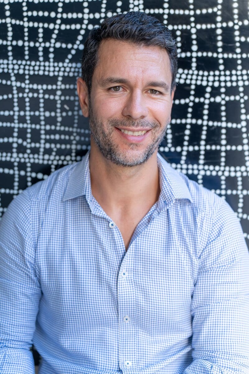 Dark hair man with beard wearing a light blue shirt and smiling having his dating photo taken by top Sydney dating photographer Georgie