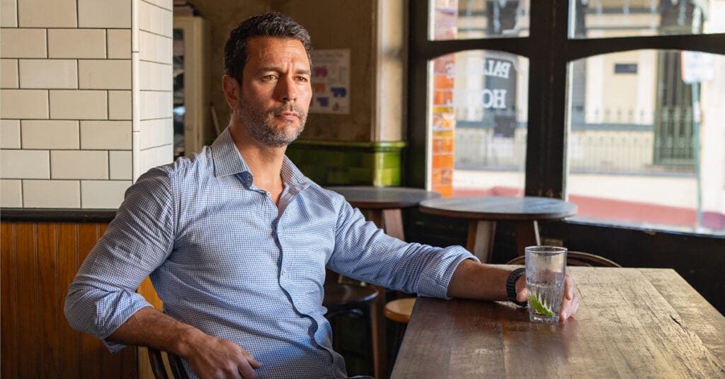 Man in a blue shirt sitting in a pub having his dating photo taken by top Sydney dating photographer Georgie Greene