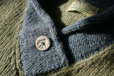 Soft handmade wool sweater with Seacolors Yarnery branding, showcasing high-quality dyed and hand-crafted wool yarn for cozy, sustainable knitting projects.