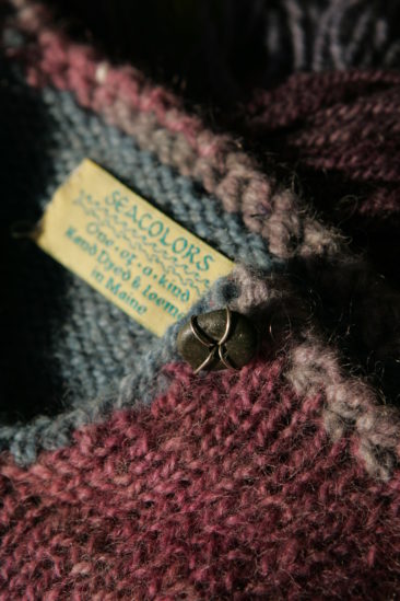 Soft, colorful Seacolors Yarnery yarn with a textured knit pattern, featuring a Maine-made label and a decorative metal charm, perfect for cozy knitting projects and vibrant handcrafted creations.