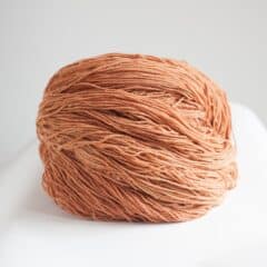 Vivid orange yarn ball from SeaColors Yarnery, perfect for knitting, crocheting, and fiber arts projects, made with sustainable, high-quality materials for vibrant handmade creations.