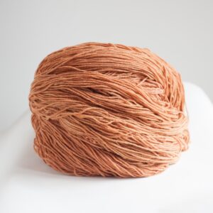 Vivid orange yarn ball from SeaColors Yarnery, perfect for knitting, crocheting, and fiber arts projects, made with sustainable, high-quality materials for vibrant handmade creations.