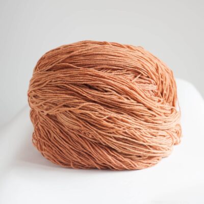 Vivid orange yarn ball from SeaColors Yarnery, perfect for knitting, crocheting, and fiber arts projects, made with sustainable, high-quality materials for vibrant handmade creations.