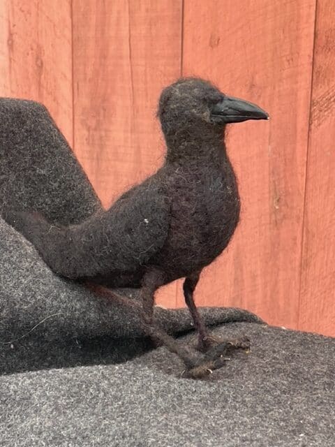Black felted bird sculpture, handcrafted with wool from Seacolors Yarnery, showcasing unique fiber art and wool crafting techniques. Perfect for wool art enthusiasts and craft lovers.