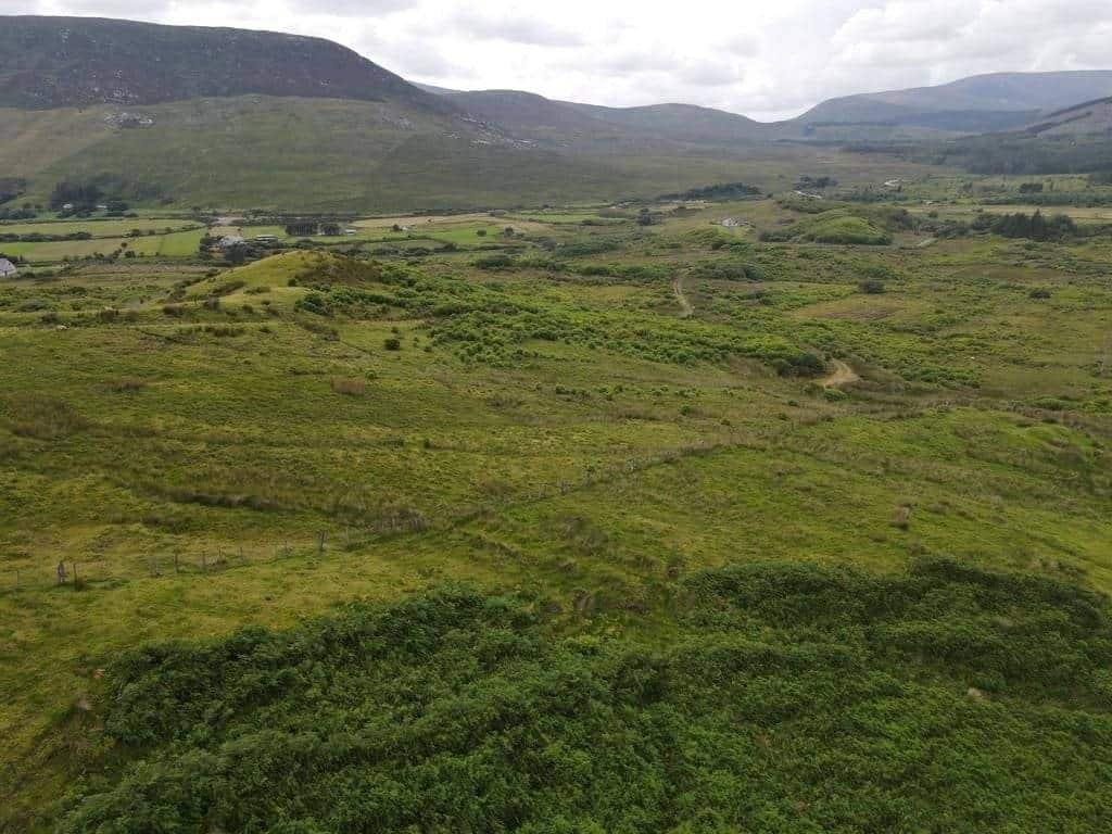 Green landscape with hills and mountains, a derelict house and shed in Mayo land. – Ghar.ie property listing