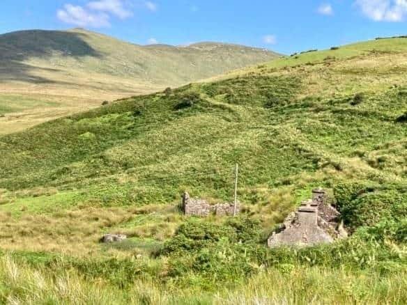 Derelict house and shed in a green, hilly landscape in Derry Brock, County Mayo. – Ghar.ie property listing