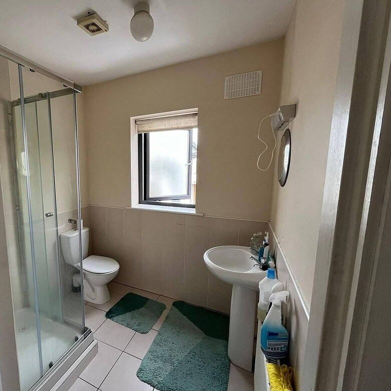 Ensuite bathroom with shower, toilet, sink, window, and green mats in a double room. – Ghar.ie property listing