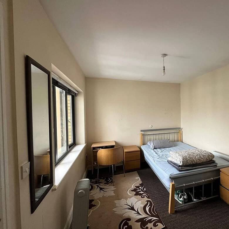 Double room in Dublin 22 with a single bed, desk, and ensuite door visible. – Ghar.ie property listing